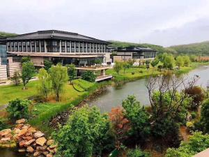 un gran edificio con un río delante de él en Primus Hotel Qipan Moutain Shenyang, en Shenyang