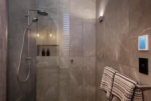 a bathroom with a shower with a glass door at Hotel Fitzroy curated by Fable in Auckland