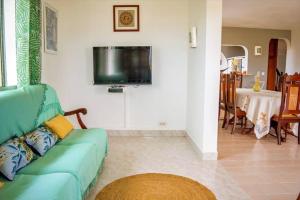 a living room with a couch and a flat screen tv at Le Domaine de Boisvin in Sainte-Anne