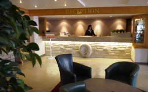 a woman standing at a reception desk in a lobby at Heights Hotel in Portland