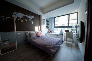 1 dormitorio con 1 cama con mapa en la pared en Ken's Joy Inn en Kaohsiung