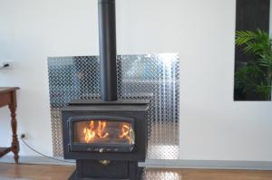 a black stove with a fire in a room at Blue Lake Holiday Park in Mount Gambier