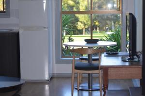 a dining room table in front of a window at Blue Lake Holiday Park in Mount Gambier