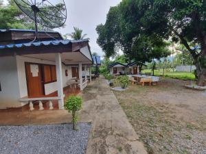 a house with a bench and a table in front of it at pineapple resort in Ban Huai Thalaeng Phan