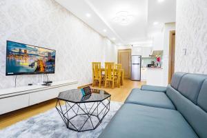 a living room with a blue couch and a kitchen at MUONGTHANH APARMENT OCEAN - 2 Bedrooms in Da Nang
