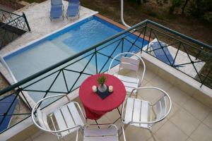 a table and chairs on a balcony next to a pool at SEMIRAMIS SUITES with pool and private jacuzzi in Kalamata