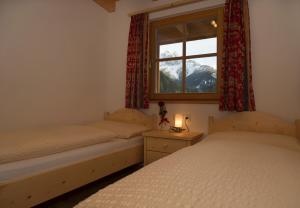 two twin beds in a room with a window at Appartments Jagerhof in Braies