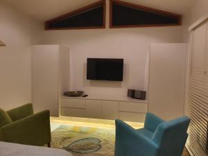 a living room with two chairs and a flat screen tv at Twenty on Lake in North Avoca