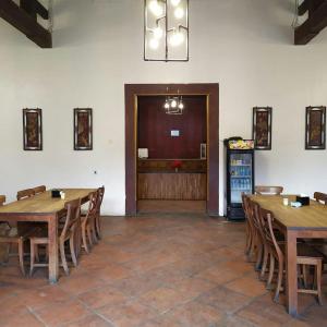 una sala da pranzo con tavoli in legno e frigorifero di Antika Hotel a Rembang