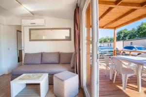 salon z kanapą i stołem w obiekcie Mobile Homes Delta Marine at Campsite Rapoća w mieście Nerezine