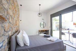 a bedroom with a bed and a stone wall at Kastalys Villa in Kalithies