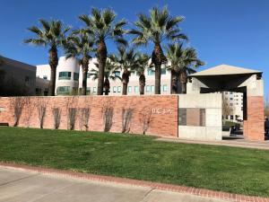 a brick wall with palm trees in front of a building at Perfect Apt near UCLA w Parking Gym Pool WIFI in Westwood B3 in Los Angeles