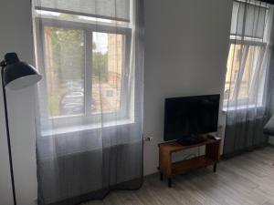 ein Wohnzimmer mit einem TV und einem Fenster in der Unterkunft SUNBEAM DESIGN APARTMENT in Riga