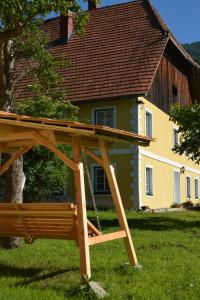 a wooden swing in front of a house at Wastlhof am Kreischberg in Lutzmannsdorf