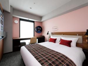 a bedroom with a large bed with red pillows at DEL style Osaka Shin Umeda by Daiwa Roynet Hotel in Osaka