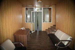 a waiting room with chairs and a table and stairs at Parade Allure in Zhashkiv