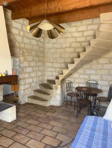 Zimmer mit einer Treppe, einem Tisch und Stühlen in der Unterkunft Les Olivades in Vauvert