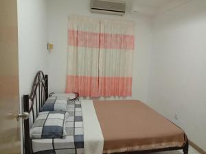 een kleine slaapkamer met 2 bedden en een raam bij Paradise Lagoon apartment in Port Dickson
