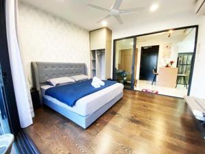 a bedroom with a bed with blue sheets and a ceiling at Almas Suites Puteri Harbour in Nusajaya