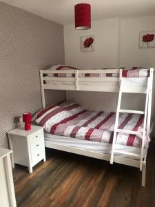 a bedroom with two bunk beds with a red candle at Plough Cottage in Bradfield