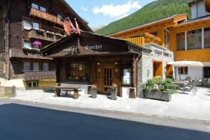 un edificio con una mesa de picnic delante de él en Swissflair Apartments, en Zermatt