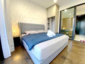 a bedroom with a large bed with a blue blanket at Almas Suites Puteri Harbour in Nusajaya