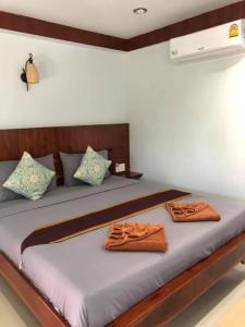 a bedroom with a bed with two towels on it at Grand Beach Resort in Koh Tao