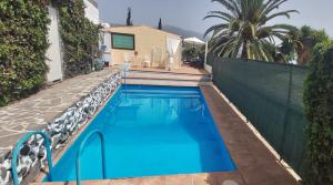 una piscina con acqua blu di fronte a una casa di Casitas Las Pereras a Los Llanos de Aridane