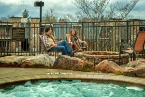 a man and a woman sitting on a bench in front of a pool at The Residences at Biltmore - Asheville in Asheville