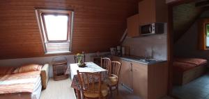 eine Küche und ein Esszimmer mit einem Tisch und einem Fenster in der Unterkunft Foki Apartman in Sopron-Balf