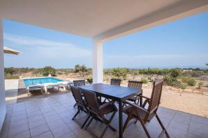 um pátio com uma mesa e cadeiras e uma piscina em VILLA Can Guillem d'es Puig em Sant Francesc Xavier