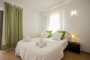 サン・フランセスク・ハヴィエルにあるVILLA Can Guillem d'es Puigのベッドルーム1室(ベッド2台、緑と白の枕付)