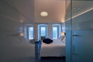 a hotel room with a bed and a glass wall at Hotel Grotta Palazzese in Polignano a Mare