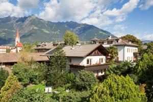 a group of houses in a village with mountains at Hotel Gruberhof in Merano