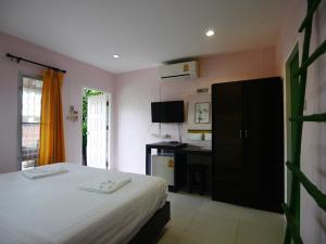 ein Schlafzimmer mit einem Bett und einem Schreibtisch darin in der Unterkunft Forest Bungalows & Mama's Restaurant in Chalong  + 51 Fotos