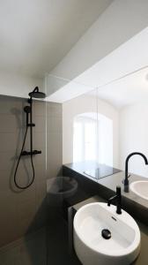 a bathroom with a white sink and a shower at ENTZÜCKENDE KLEINE WOHNUNG in Linz