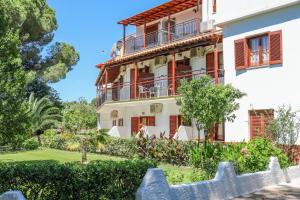 a large white building with red shutters at Sergios in Koukounaries