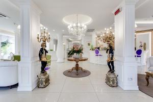 a living room with white walls and a chandelier at Hotel Il Gabbiano in Cesenatico