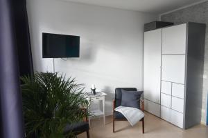 a living room with a chair and a tv on a wall at Hafenstunde in Neubrandenburg