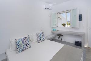 a white room with a white couch and a window at Aspries Suites in Piso Livadi