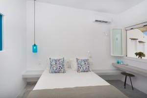 a white room with a bed and a window at Aspries Suites in Piso Livadi