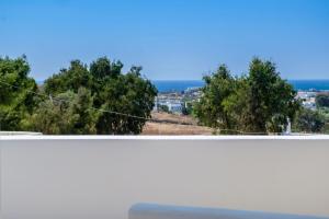 a view of the ocean from a balcony with trees at Aspries Suites in Piso Livadi