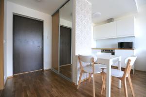 a kitchen and dining room with a table and chairs at Lys Apartments City Center in Pärnu