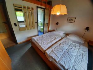 sypialnia z dużym białym łóżkiem z lampką w obiekcie Ferienhaus Robinson 113 w mieście Waldbrunn