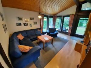 ein Wohnzimmer mit einem Sofa und einem Tisch in der Unterkunft Ferienhaus Robinson 113 in Waldbrunn