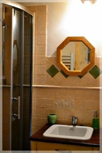 a bathroom with a sink and a mirror on the wall at Dom Gościnny Szpilkowo in Nowica