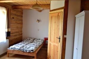 a bedroom with a bed and an open door at Dom Gościnny Szpilkowo in Nowica