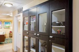 a row of glass cabinets in a room with a room at Candlewood Suites Medford by IHG in Medford +25 photos