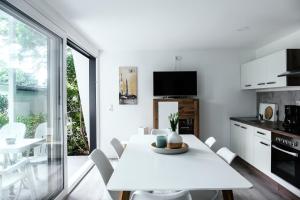 a kitchen and dining room with a white table and chairs at Bungalowpark am Salzhaff in Klein Strömkendorf
