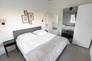 une chambre avec un grand lit et un miroir dans l'établissement Ostseehaus am Naturstrand - Ostseeblick, à Varnkevitz